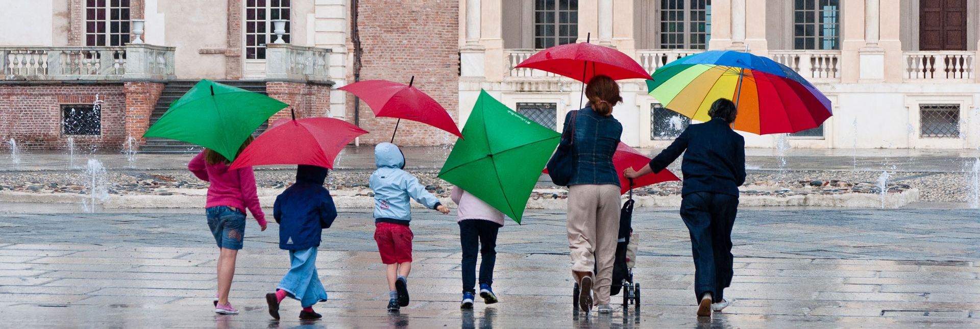 Visitatori con ombrelli colorati nella Corte d'onore