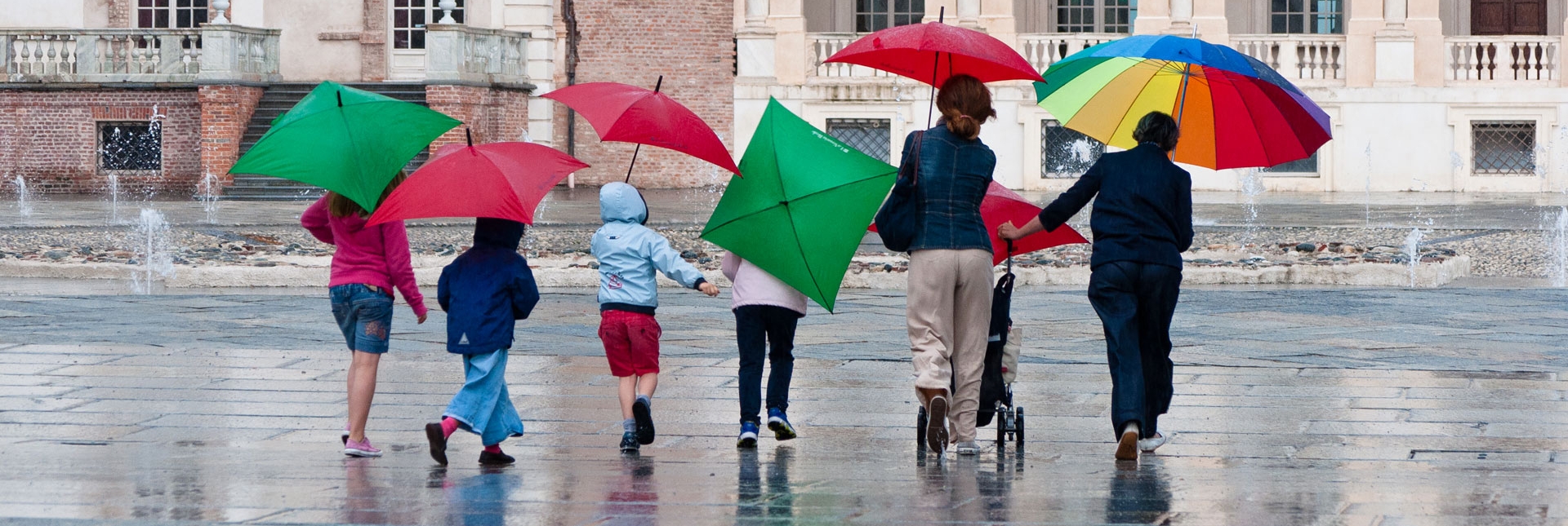 Visitatori con ombrelli colorati nella Corte d'onore