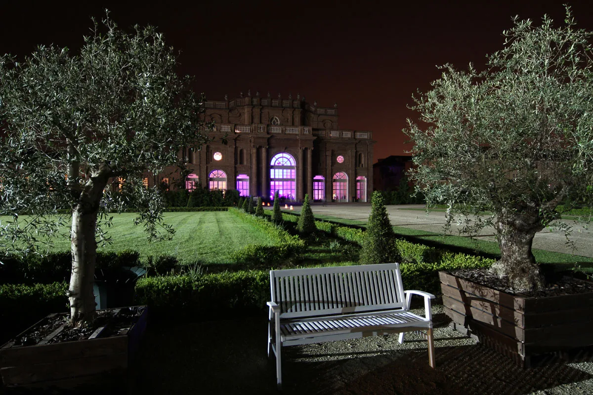 Facciata Citroniera e olivi nei Giardini della Reggia di sera