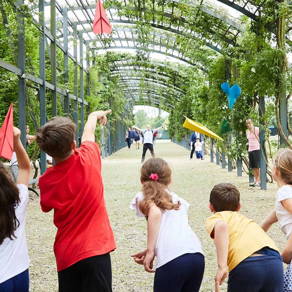 Bambini giocano con aeroplanini di carta nee Giardini della Reggia