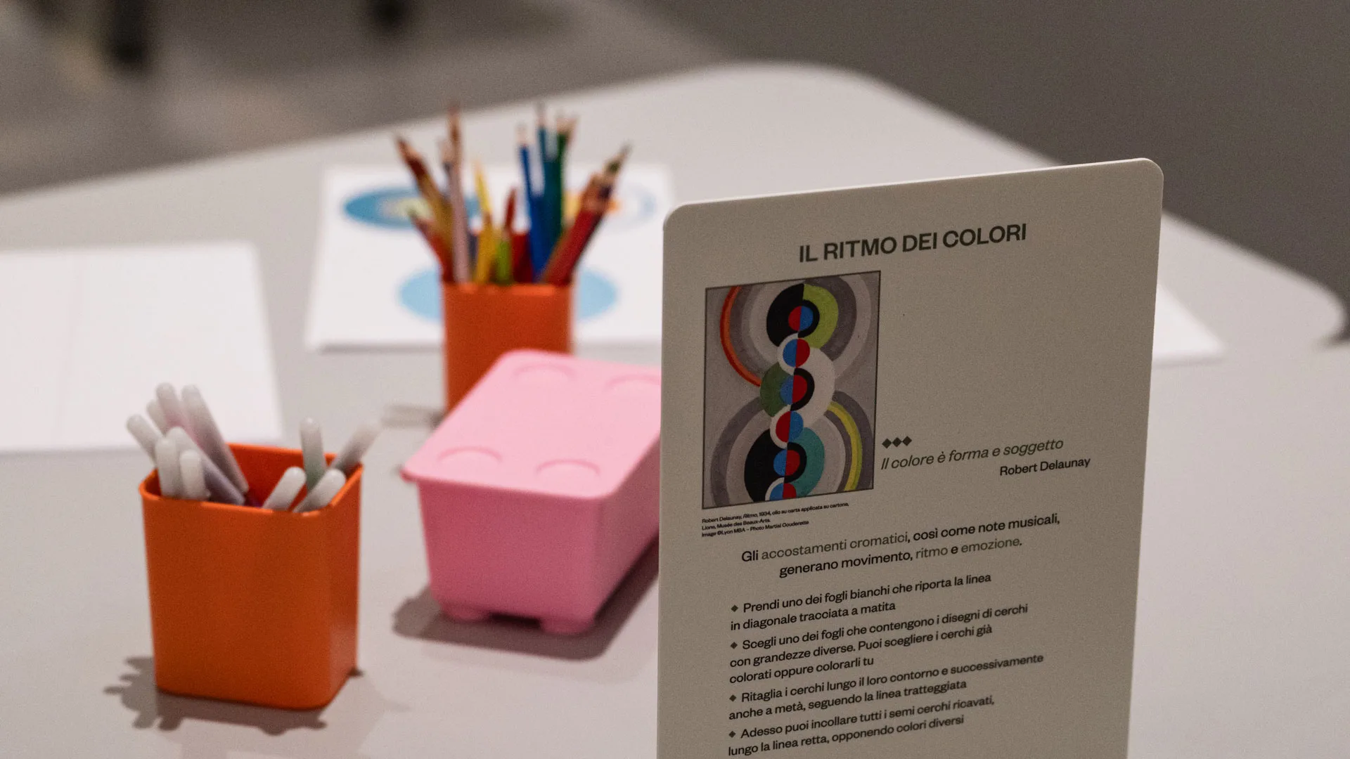 Matite colorate e istruzioni per le attività nell'atelier della mostra